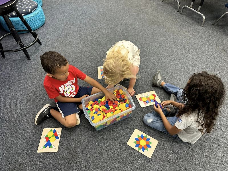 Students on floor working on puzzles