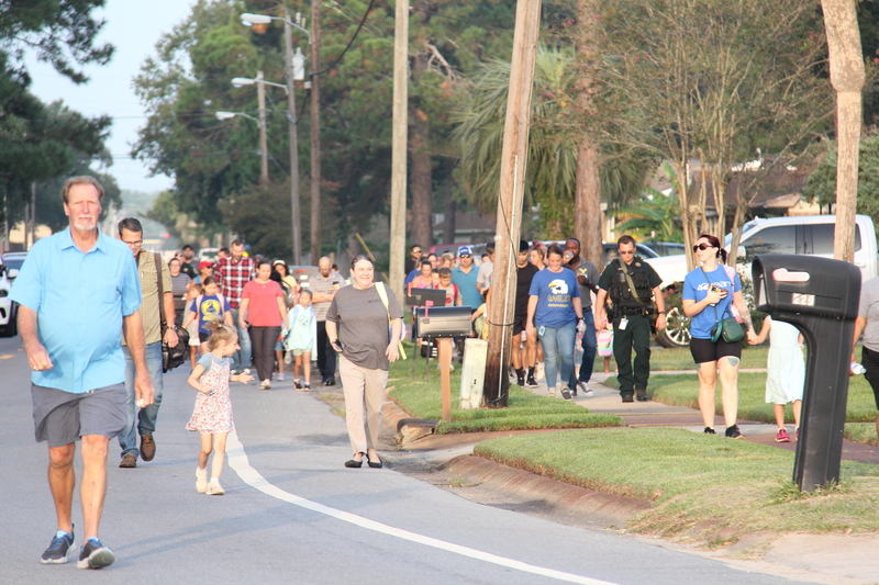 Students, families, and community members walking to school.