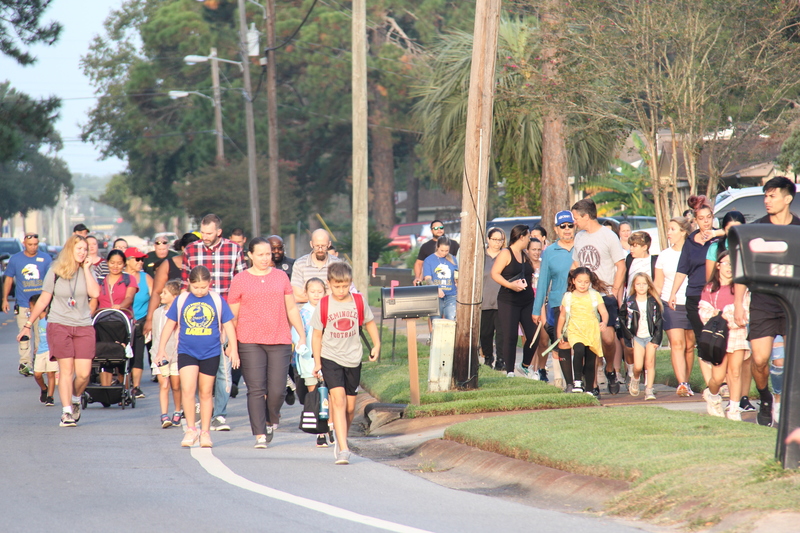 Students, families, and community members walking to school.