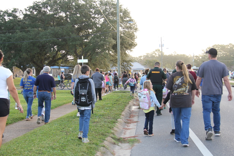 Students, families, and community members walking to school.